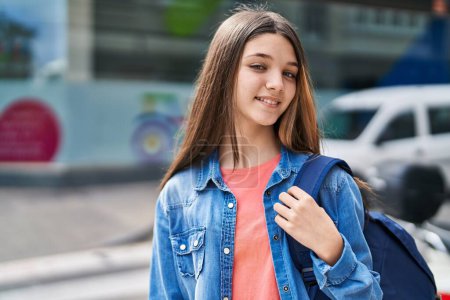 Adorable girl student smiling confident wearing backpack at street