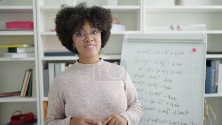 Photo for Young african american woman teacher teaching maths lesson at university classroom - Royalty Free Image