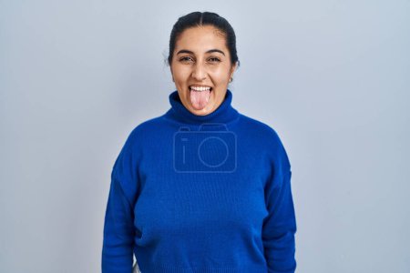 Téléchargez les photos : Jeune femme hispanique debout sur fond isolé langue collante heureux avec une expression drôle. concept d'émotion. - en image libre de droit