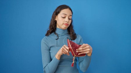 Photo for Young beautiful hispanic woman showing empty wallet over isolated blue background - Royalty Free Image