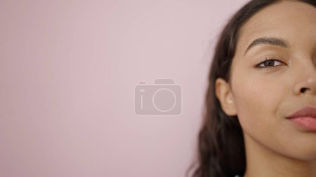 Foto de Joven mujer hispana hermosa primer plano de expresión seria sobre fondo rosa aislado - Imagen libre de derechos