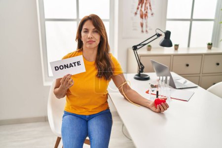 Photo for Hispanic woman supporting blood donation skeptic and nervous, frowning upset because of problem. negative person. - Royalty Free Image