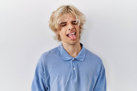 Photo for Young modern man standing over isolated background sticking tongue out happy with funny expression. emotion concept. - Royalty Free Image