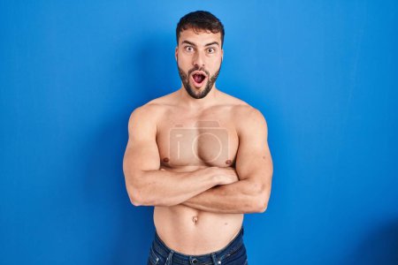 Photo for Handsome hispanic man standing shirtless afraid and shocked with surprise expression, fear and excited face. - Royalty Free Image