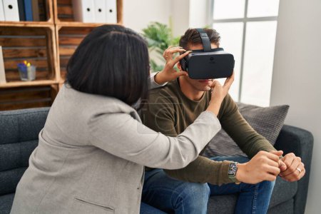 Téléchargez les photos : Homme et femme ayant une séance de psychologie de la réalité virtuelle à la clinique - en image libre de droit
