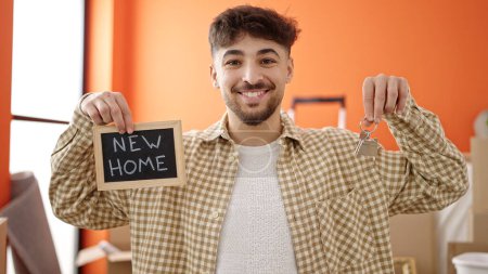 Téléchargez les photos : Jeune homme arabe tenant tableau noir et clés à la nouvelle maison - en image libre de droit