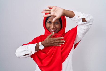Téléchargez les photos : Jeune femme arabe portant l'écharpe traditionnelle islamique hijab souriant joyeux jeu jeter un coup d'oeil un boo avec les mains montrant le visage. surpris et sortis - en image libre de droit