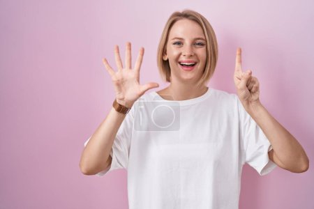 Téléchargez les photos : Jeune femme caucasienne debout sur fond rose montrant et pointant vers le haut avec les doigts numéro six tout en souriant confiant et heureux. - en image libre de droit
