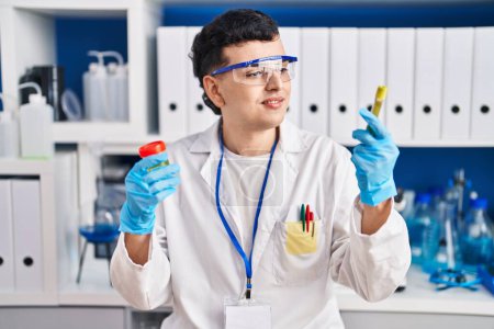 Photo for Young non binary man scientist holding urine test tubes at laboratory - Royalty Free Image