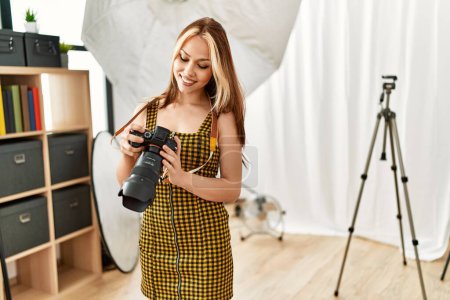 Photo for Young caucasian woman photographer holding professional camera photo studio - Royalty Free Image