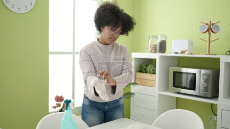 Foto de Mujer afroamericana joven usando guantes para limpiar en casa - Imagen libre de derechos