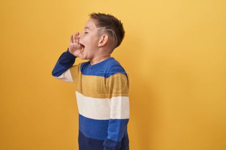 Photo for Little hispanic boy standing over yellow background clueless and confused with open arms, no idea and doubtful face. - Royalty Free Image