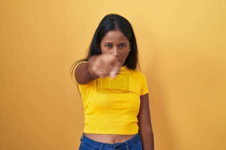 Téléchargez les photos : Jeune femme indienne debout sur fond jaune pointant mécontent et frustré à la caméra, en colère et furieux contre vous - en image libre de droit