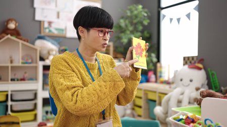 Photo for Young chinese woman preschool teacher having vocabulary lesson at kindergarten - Royalty Free Image