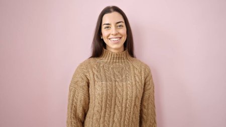 Foto de Young beautiful hispanic woman smiling confident standing over isolated pink background - Imagen libre de derechos
