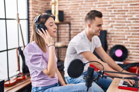Photo for Man and woman musicians listening to music composing song at music studio - Royalty Free Image