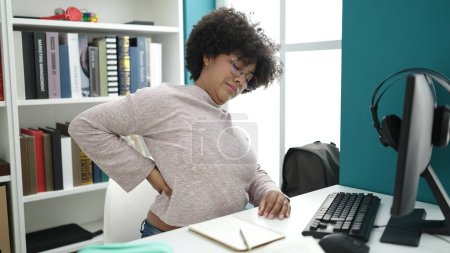 Photo for Young african american woman student using computer stressed at university classroom - Royalty Free Image