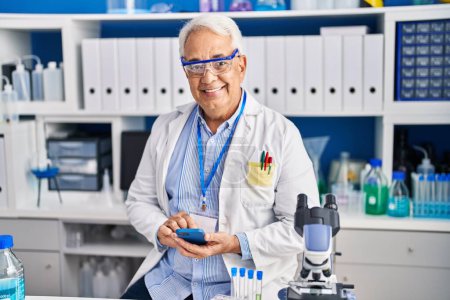 Photo for Senior man scientist using smartphone at laboratory - Royalty Free Image