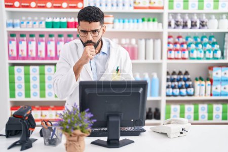 Téléchargez les photos : Homme hispanique avec la barbe travaillant à la pharmacie pharmacie sensation de malaise et la toux comme symptôme de rhume ou de bronchite. concept de soins de santé. - en image libre de droit
