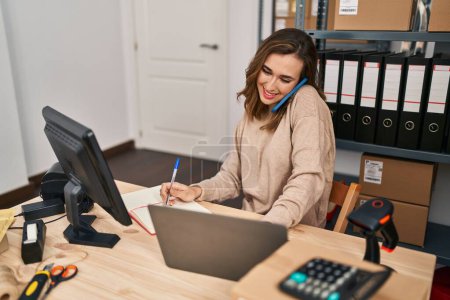 Téléchargez les photos : Young woman ecommerce business worker talking on the smartphone working at office - en image libre de droit