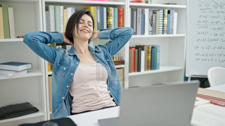 Photo for Young caucasian woman student studying relaxed with hands on head at university classroom - Royalty Free Image