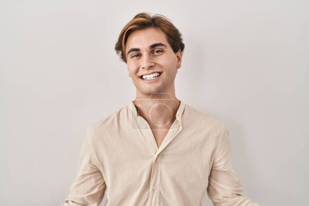 Photo for Young man standing over isolated background smiling cheerful with open arms as friendly welcome, positive and confident greetings - Royalty Free Image