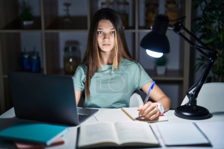 Photo for Teenager girl doing homework at home late at night depressed and worry for distress, crying angry and afraid. sad expression. - Royalty Free Image