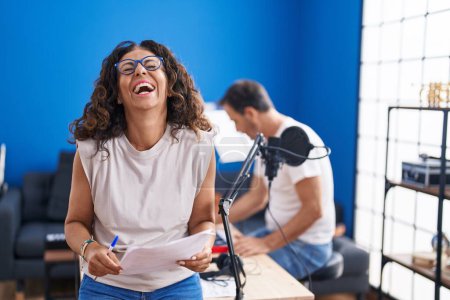 Téléchargez les photos : Moyen Age femme hispanique chantant au studio de musique souriant et riant fort à haute voix parce que drôle blague folle. - en image libre de droit
