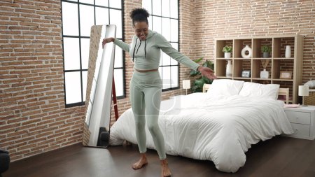 Foto de Mujer afroamericana sonriendo confiada bailando en el dormitorio - Imagen libre de derechos