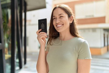 Photo for Young beautiful woman smiling confident holding canada passport at street - Royalty Free Image