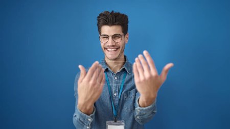 Photo for Young hispanic man smiling confident doing come gesture with hands over isolated blue background - Royalty Free Image