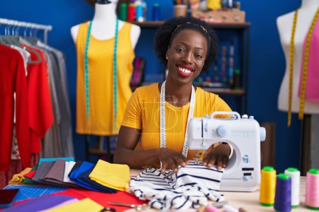 Photo for African american woman tailor smiling confident using sewing machine at sewing studio - Royalty Free Image