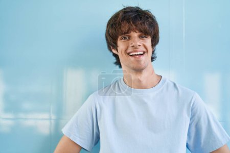 Téléchargez les photos : Young blond man smiling confident standing over isolated blue background - en image libre de droit