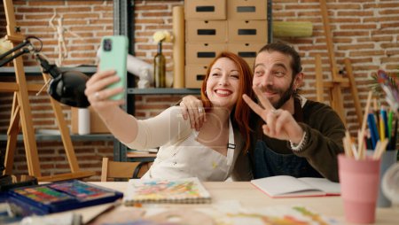 Foto de Hombre y mujer pareja hacer selfie por dibujo de teléfonos inteligentes en el estudio de arte - Imagen libre de derechos