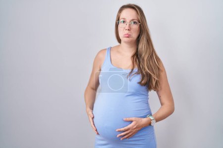 Photo for Young pregnant woman standing over white background depressed and worry for distress, crying angry and afraid. sad expression. - Royalty Free Image