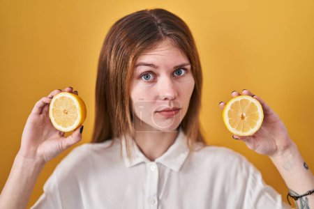 Photo for Beautiful woman holding lemons skeptic and nervous, frowning upset because of problem. negative person. - Royalty Free Image