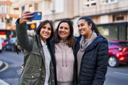 Téléchargez les photos : Three woman mother and daughters make selfie by the smartphone at street - en image libre de droit