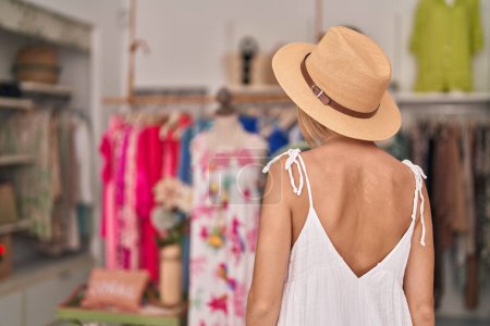 Foto de Joven cliente rubia con sombrero de verano en la tienda de ropa - Imagen libre de derechos
