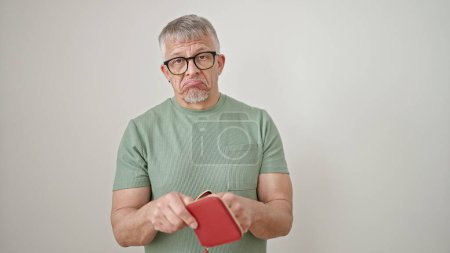 Foto de Hombre de pelo gris de mediana edad mostrando una cartera vacía sobre un fondo blanco aislado - Imagen libre de derechos