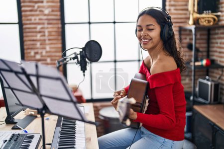 Photo for Young african american woman musician playing classical guitar at music studio - Royalty Free Image