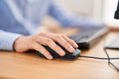 Young caucasian man using computer keyboard and mouse at office Poster #644187280