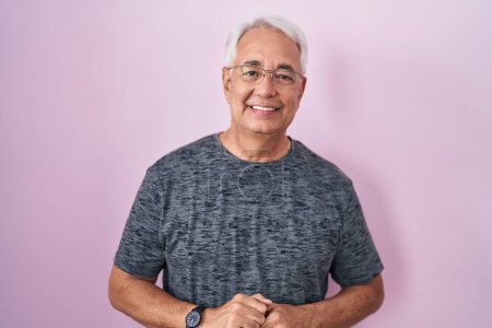 Photo for Middle age man with grey hair standing over pink background with hands together and crossed fingers smiling relaxed and cheerful. success and optimistic - Royalty Free Image