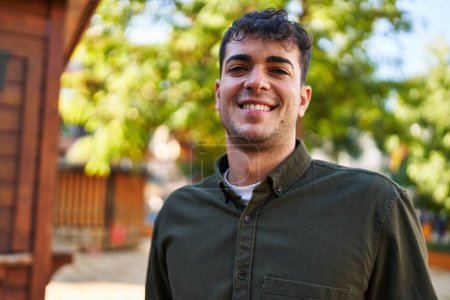 Téléchargez les photos : Jeune homme hispanique souriant confiant debout au parc - en image libre de droit