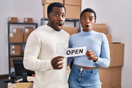 Photo for Young african american couple working at small business ecommerce afraid and shocked with surprise and amazed expression, fear and excited face. - Royalty Free Image