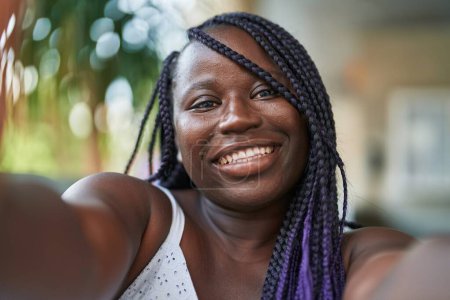 Téléchargez les photos : Afro-américaine femme souriant confiant faire selfie par caméra à la rue - en image libre de droit