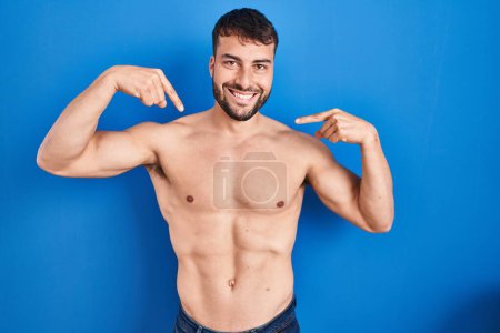 Photo for Handsome hispanic man standing shirtless looking confident with smile on face, pointing oneself with fingers proud and happy. - Royalty Free Image