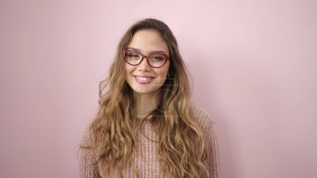 Téléchargez les photos : Young beautiful hispanic woman smiling confident wearing glasses over isolated pink background - en image libre de droit