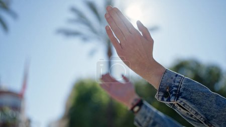 Photo for Young hispanic man with hands raised towards sky at park - Royalty Free Image