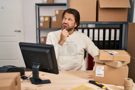 Photo for Handsome middle age man working at small business ecommerce thinking looking tired and bored with depression problems with crossed arms. - Royalty Free Image