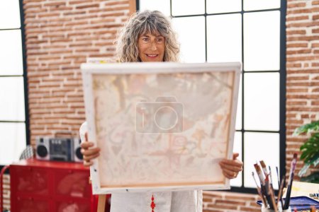 Photo for Middle age woman artist looking draw at art studio - Royalty Free Image